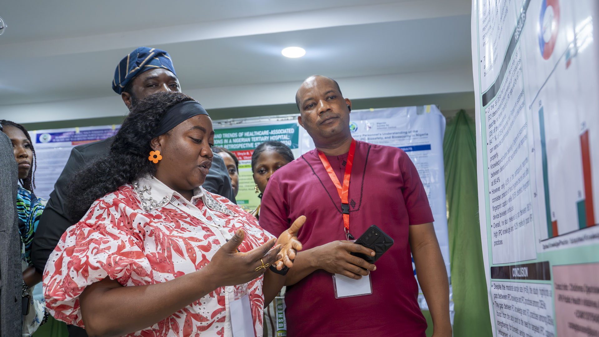 APIN researchers and stakeholders reviewing a scientific research poster presentation.